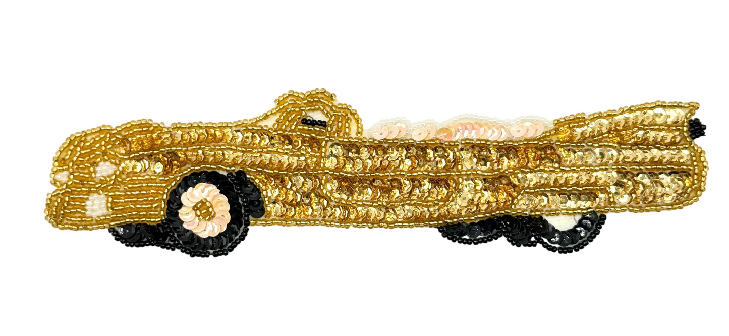 Gold sequin and bead convertible car-shaped applique with black tires on a white background