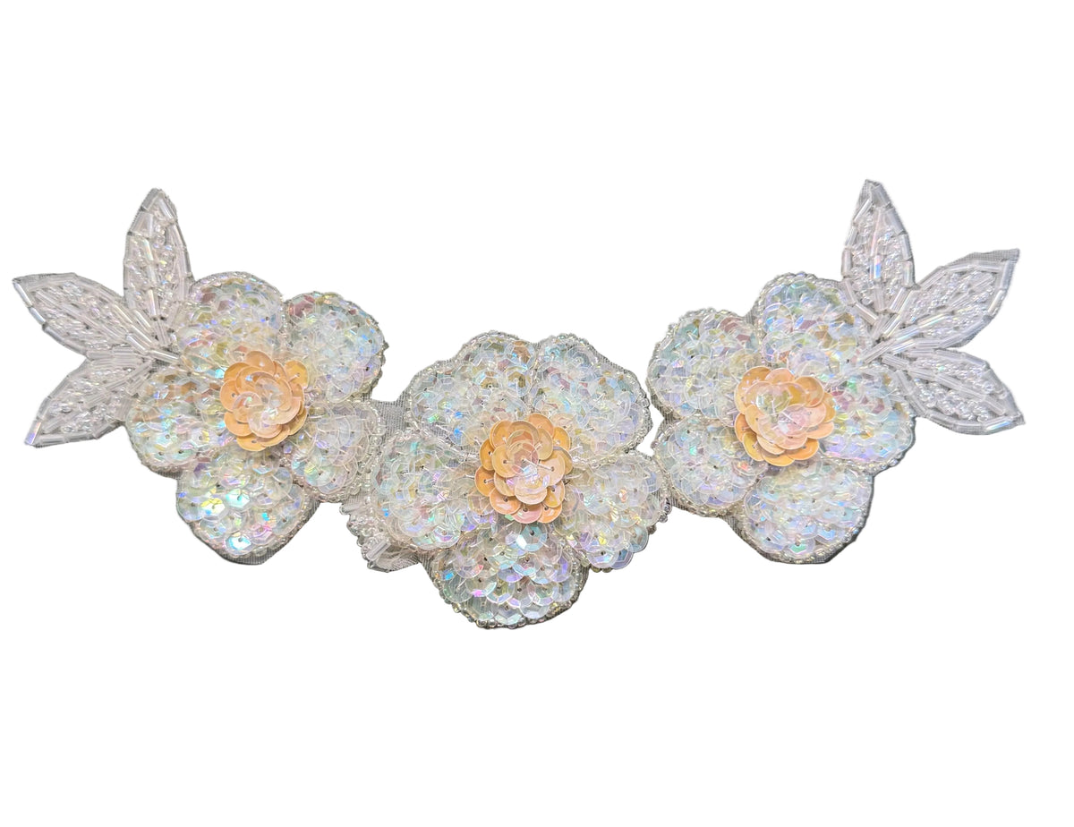 Three white sequined floral appliqués with iridescent leaves and beige centers, arranged horizontally on a white background.