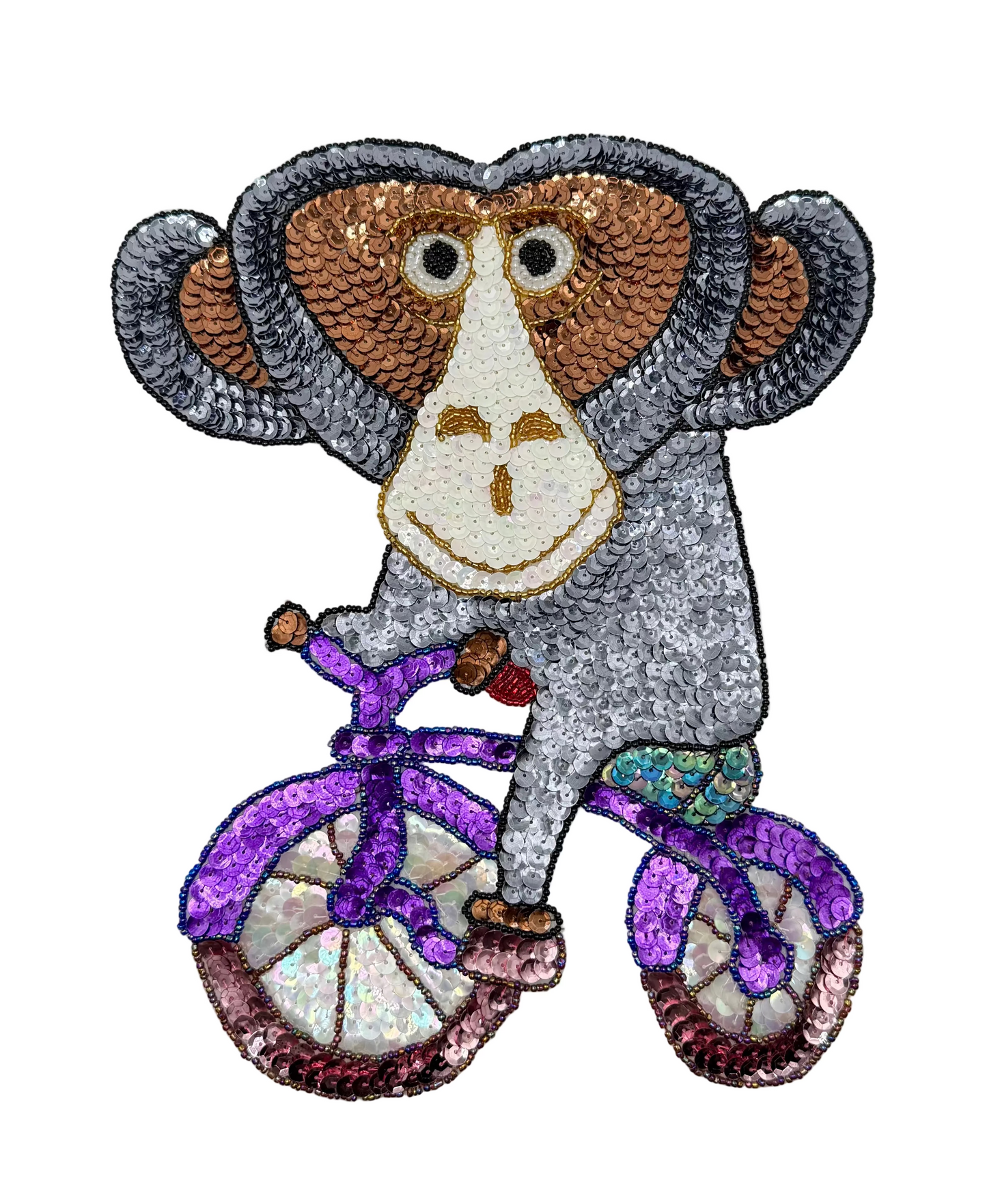 Sequined monkey riding a bicycle on a white background