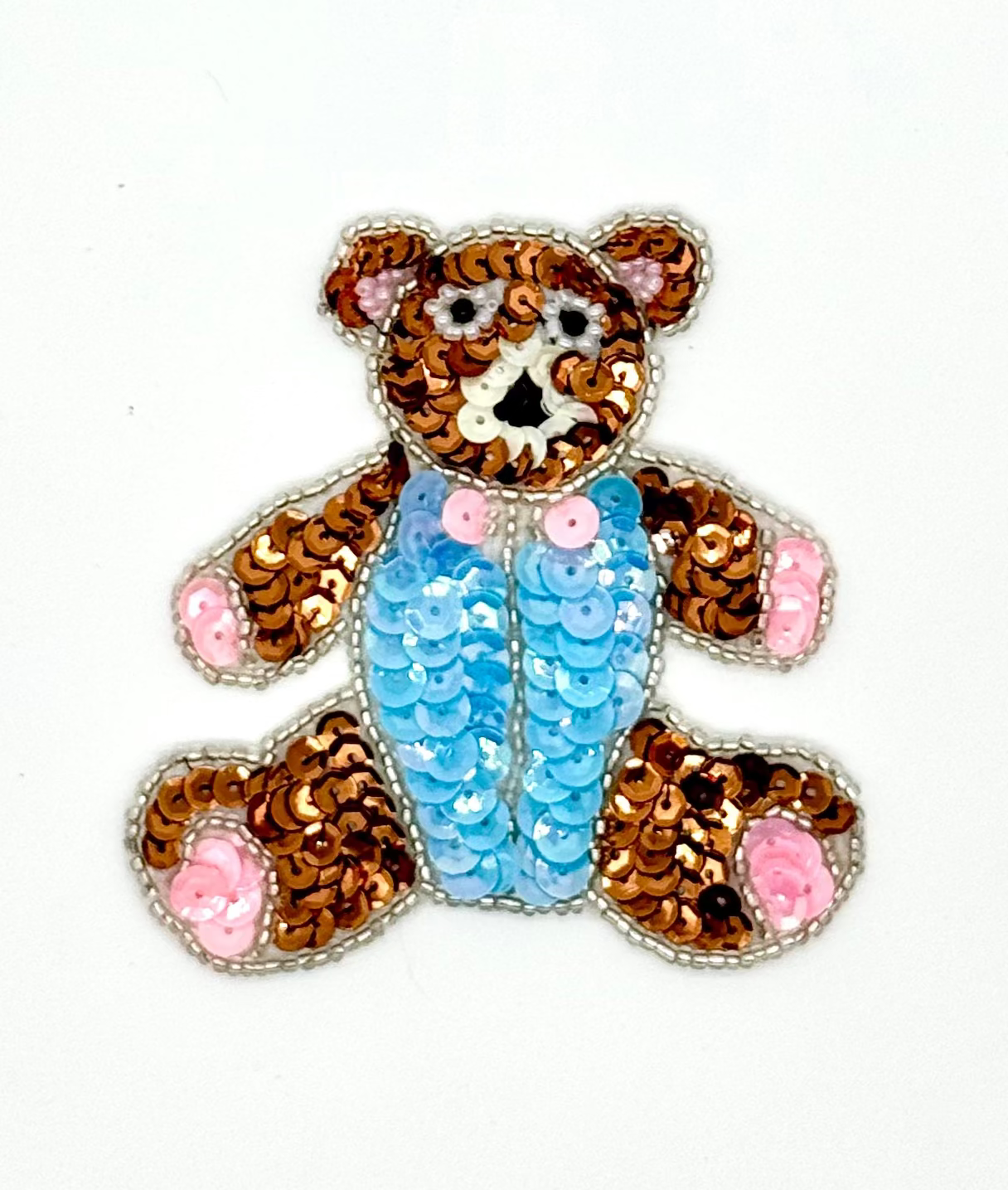 Sequined teddy bear with a blue jumper on a white background