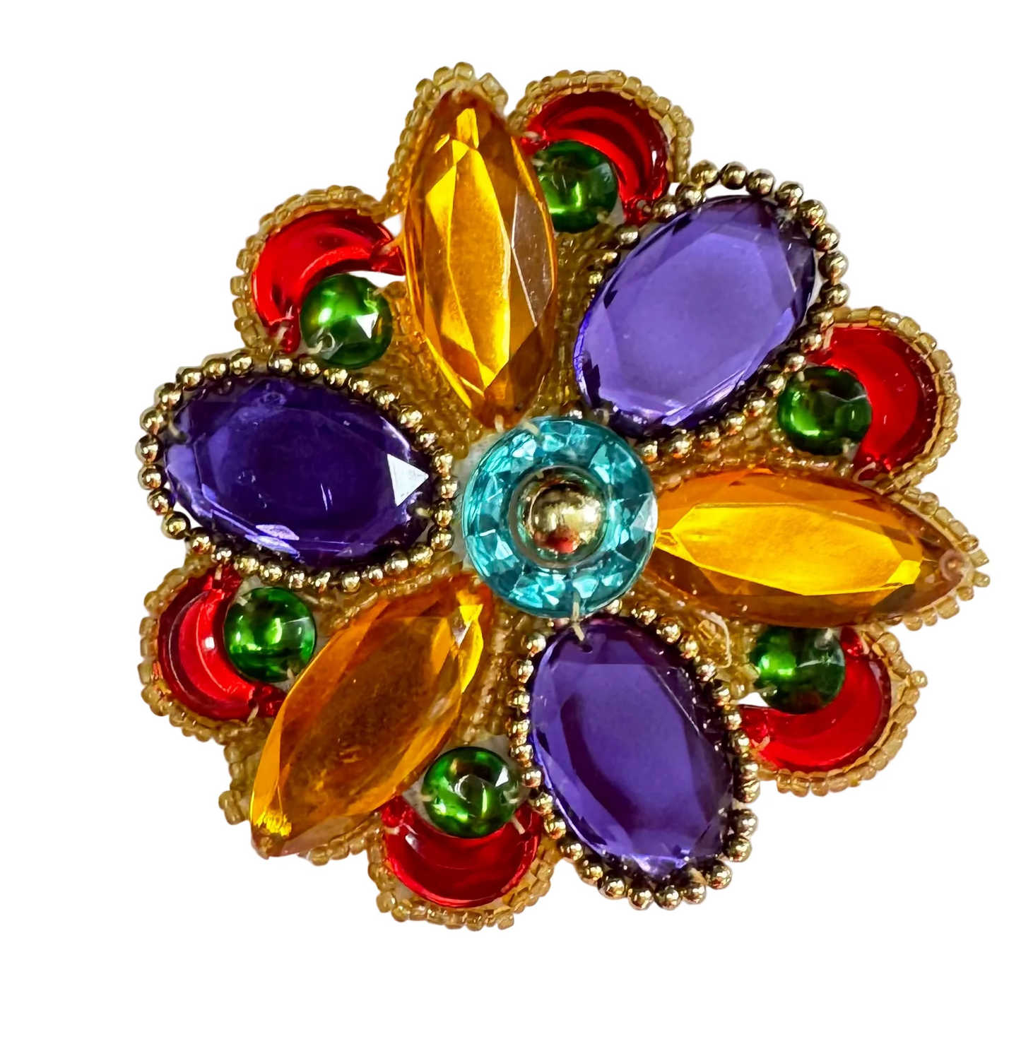 A colorful floral-style jewel patch with purple, gold, and green elements, with a central turquoise stone, surrounded by smaller red and green beads.