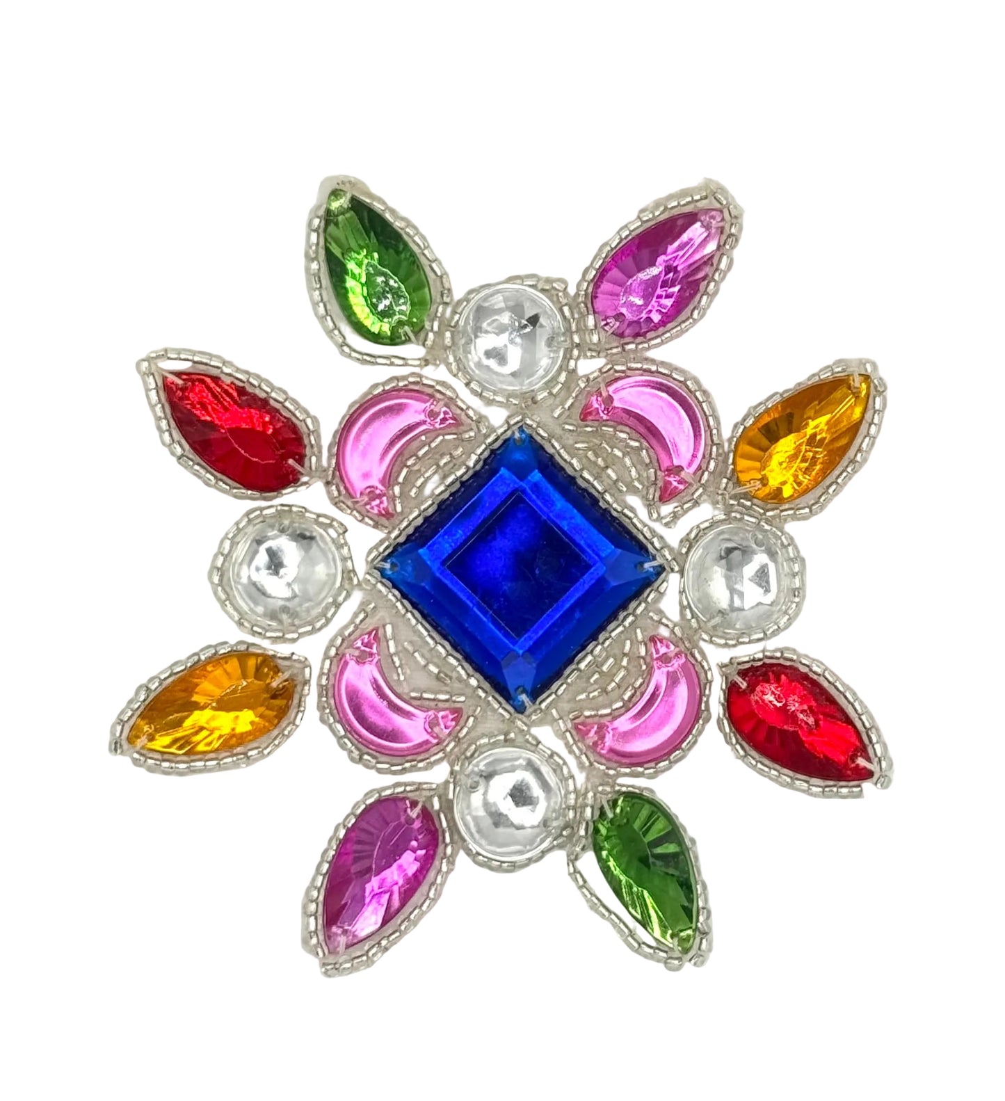 A decorative floral appliqué featuring a central royal blue diamond-shaped crystal surrounded by pink crescent-shaped stones, red and yellow teardrop-shaped stones, green teardrop-shaped stones, and silver rhinestone accents on a plain white background.