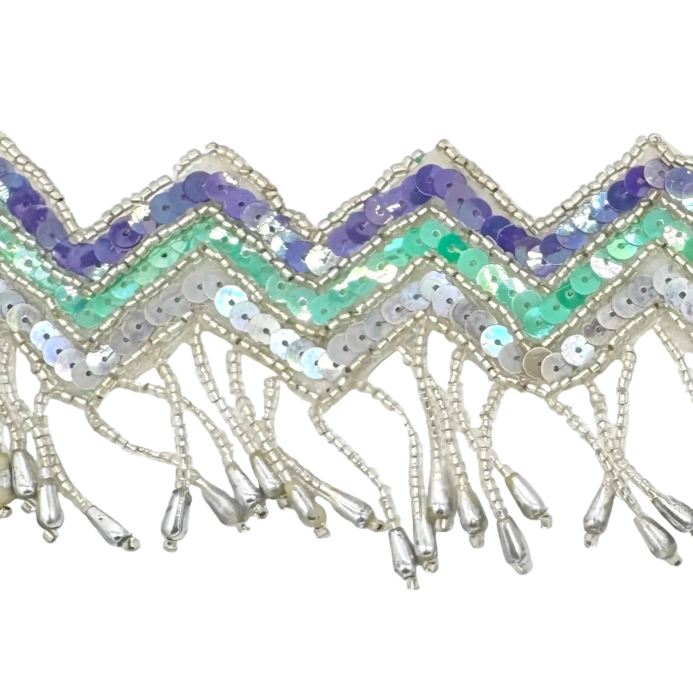 A close-up of a decorative trim featuring chevron patterns of purple, mint green, and iridescent silver sequins, finished with dangling silver bead fringes on a white background.