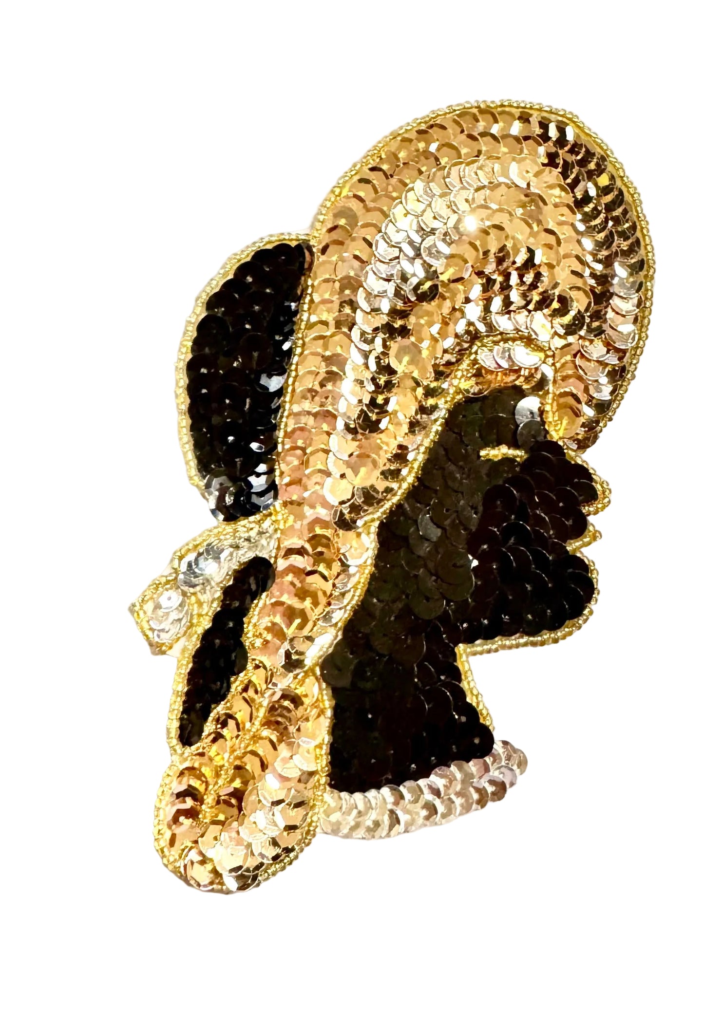 A decorative patch shaped like a stylized profile silhouette, covered in gold and black sequins with a gold beaded border, photographed on a plain light background.