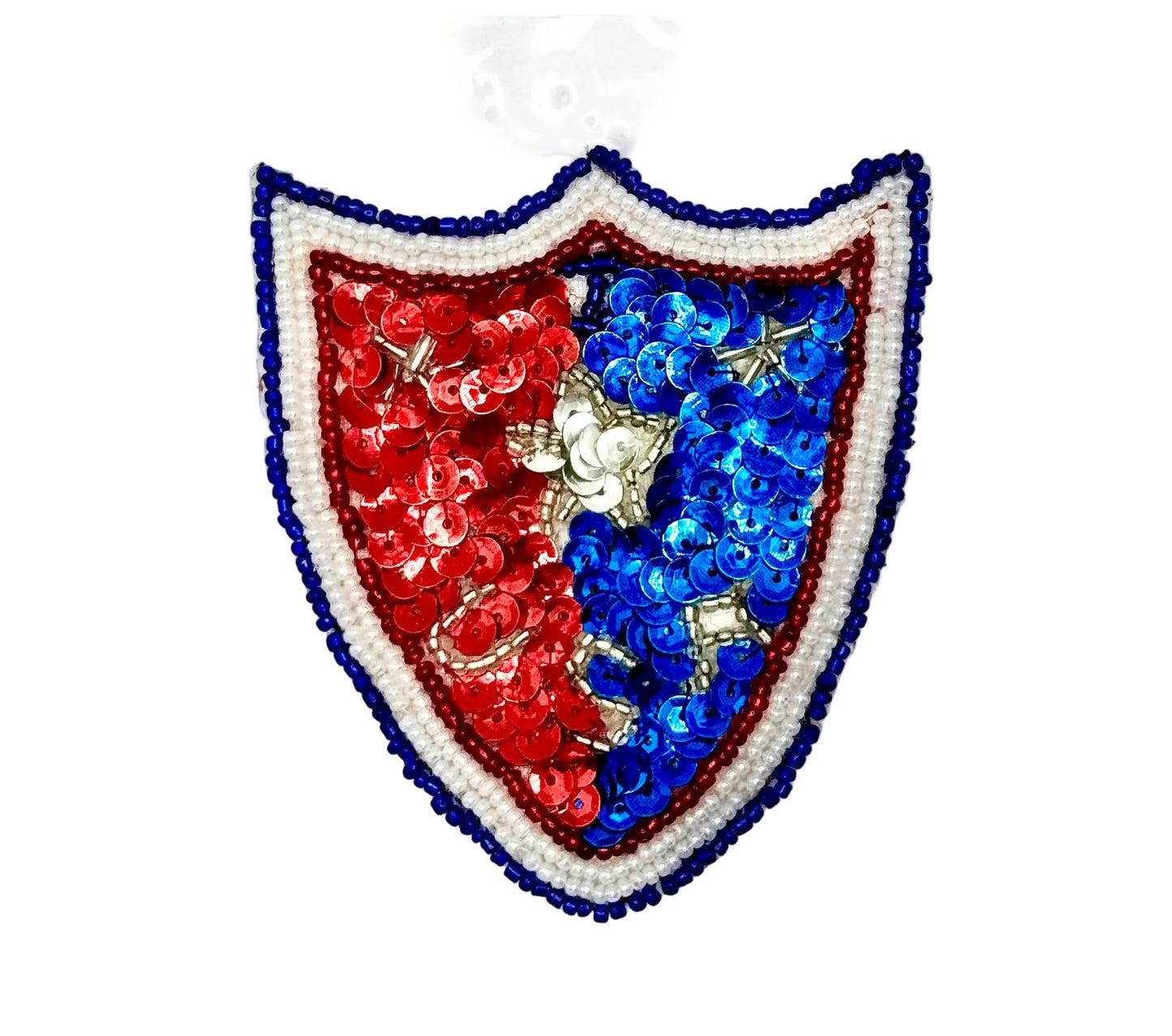 A shield-shaped sequin ornament featuring a red left side, a blue right side, and a white border with blue and red trim, shown on a plain white background.