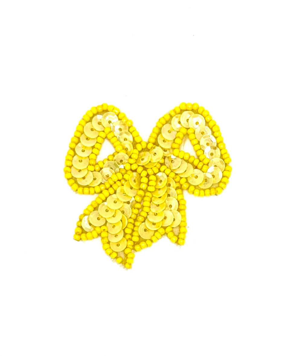 Yellow sequin bow on a white background