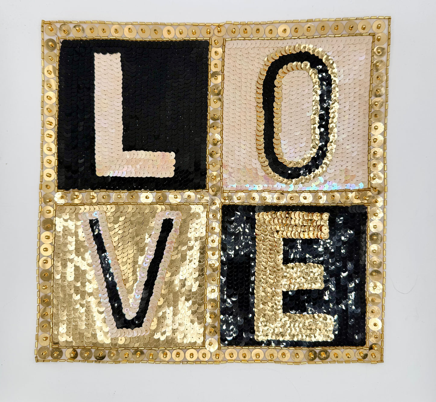 Decorative Sequin appliqué with sequin letters spelling 'LOVE' on a light gray background