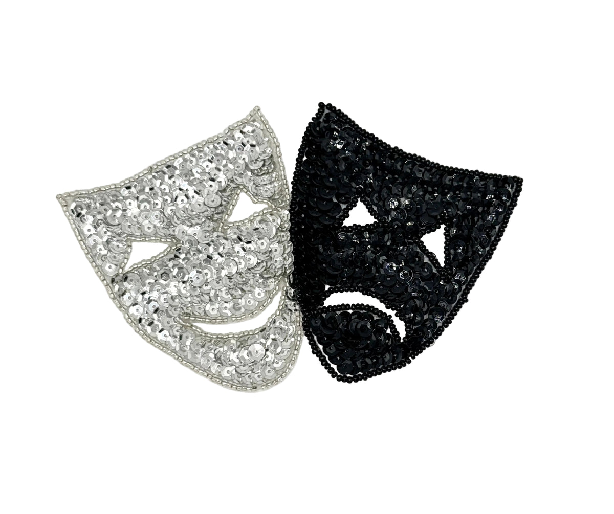 Two sequin and bead theater masks, one silver and one black, on a white background