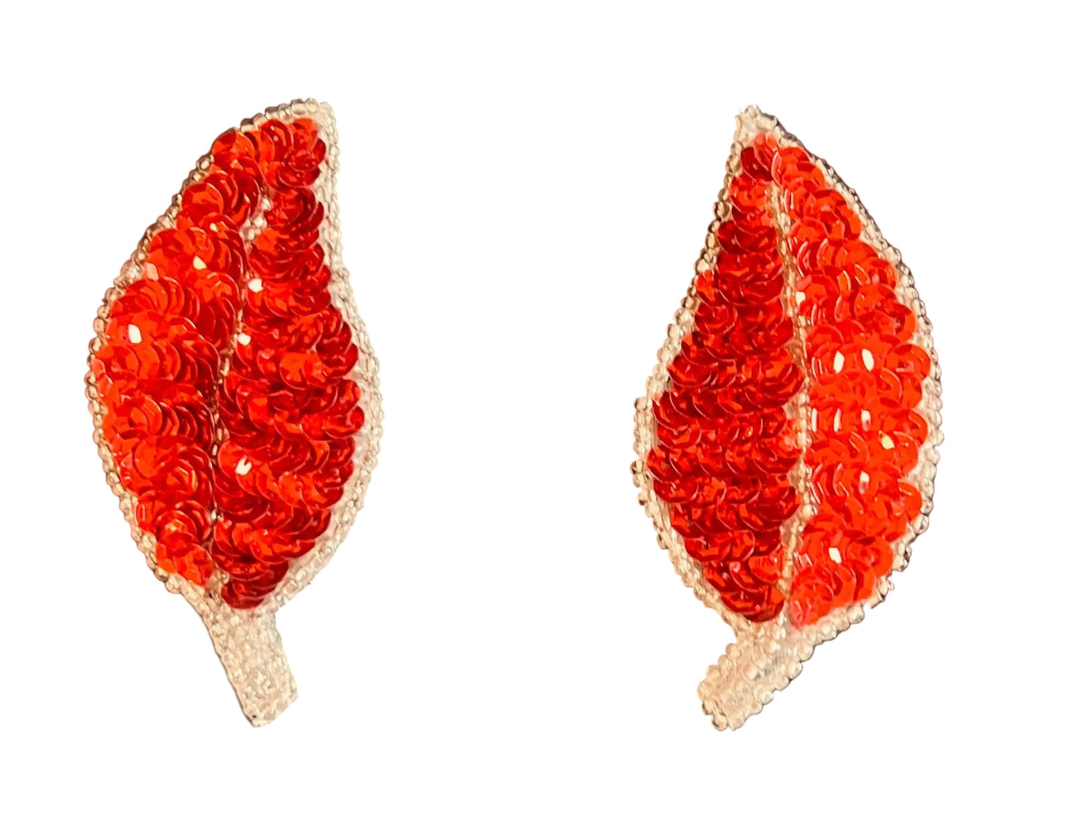 Two red leaf-shaped sequin patches on a black background