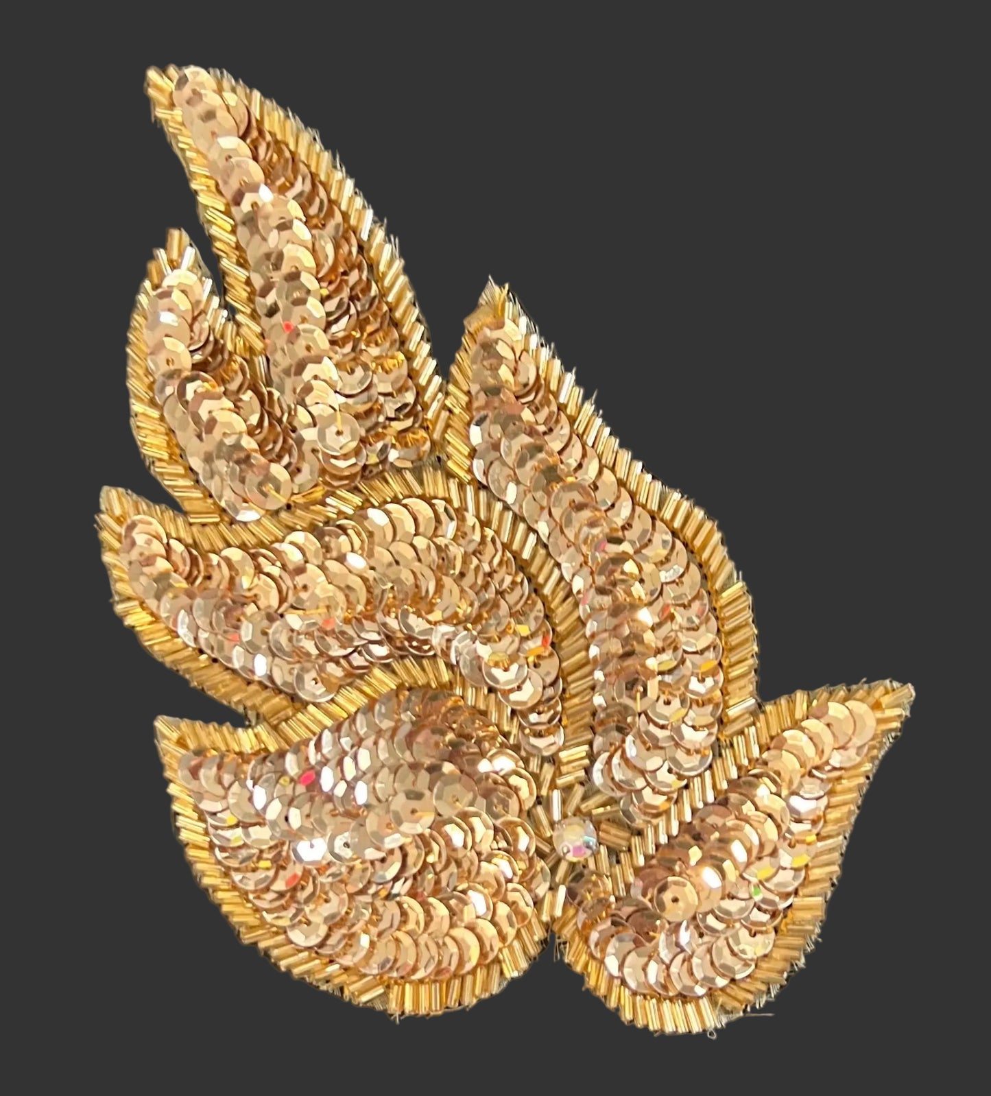 Gold sequin leaf patch on a black background