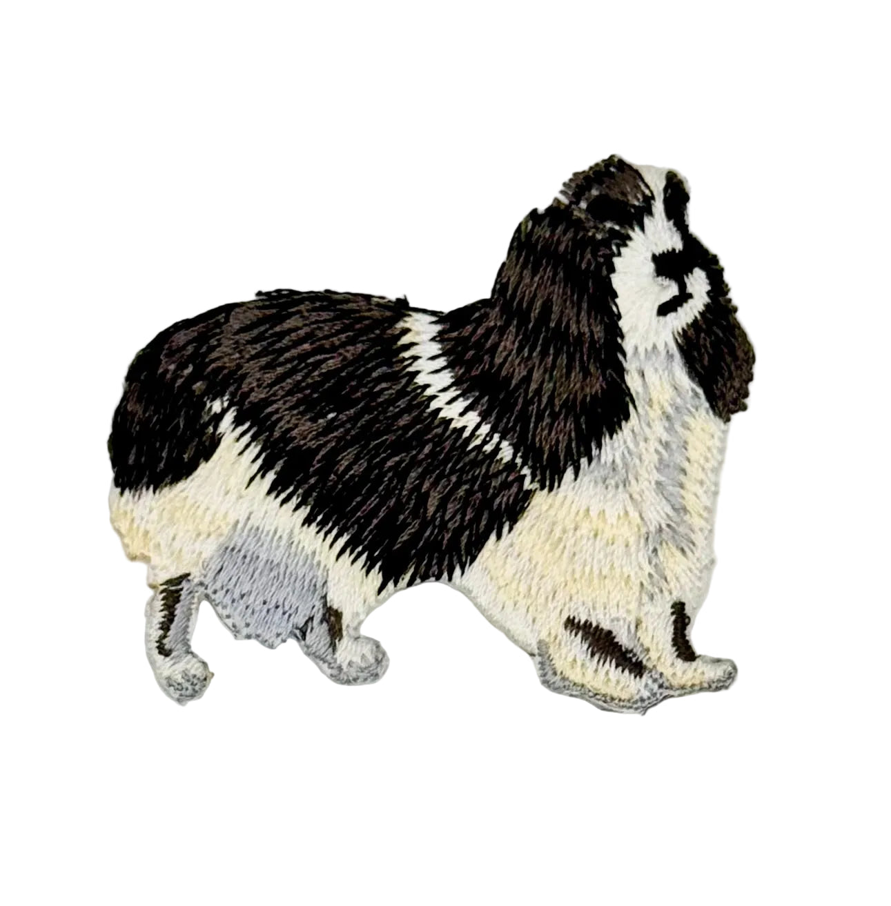 Embroidered patch of a cocker spaniel black and white on a white background