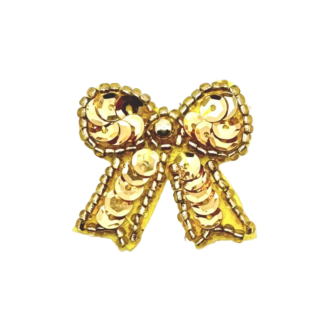 Gold bow patch with sequins and beads on a white background