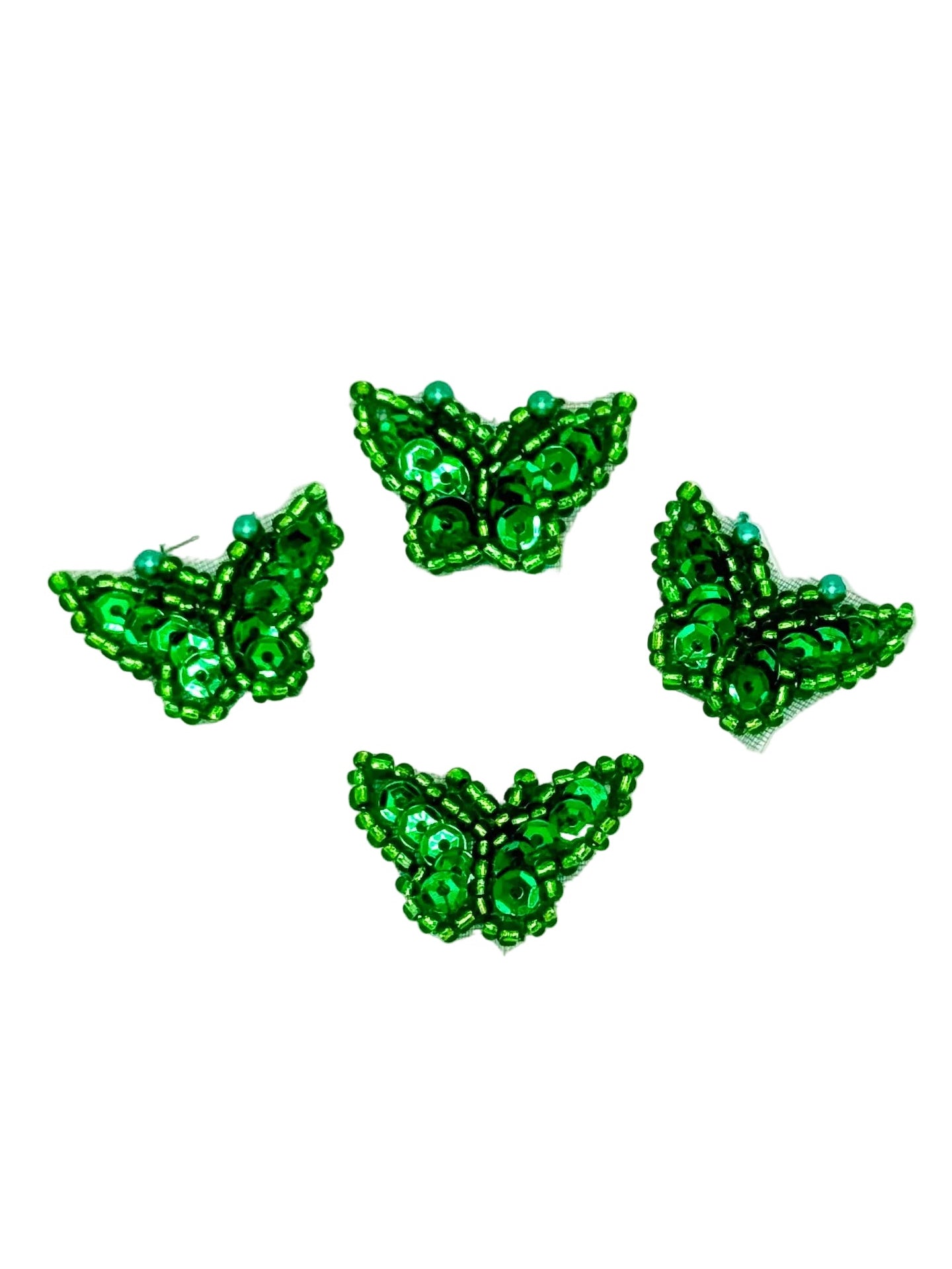 Four green butterfly-shaped sequin and bead butterflies on a white background