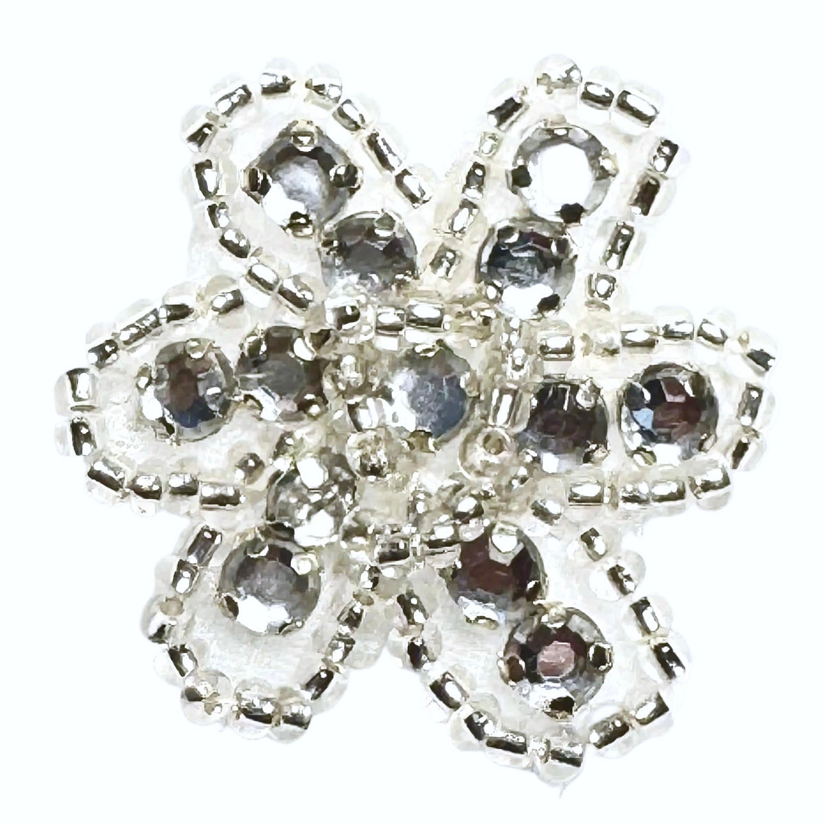 Beaded and rhinestone silver and clear flower on a white background