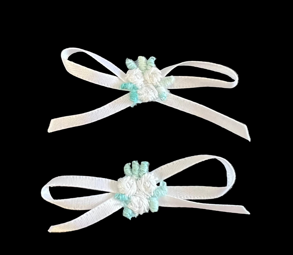 Juego de dos flores blancas con hojas verdes y un lazo blanco de 5 x 2,5 cm