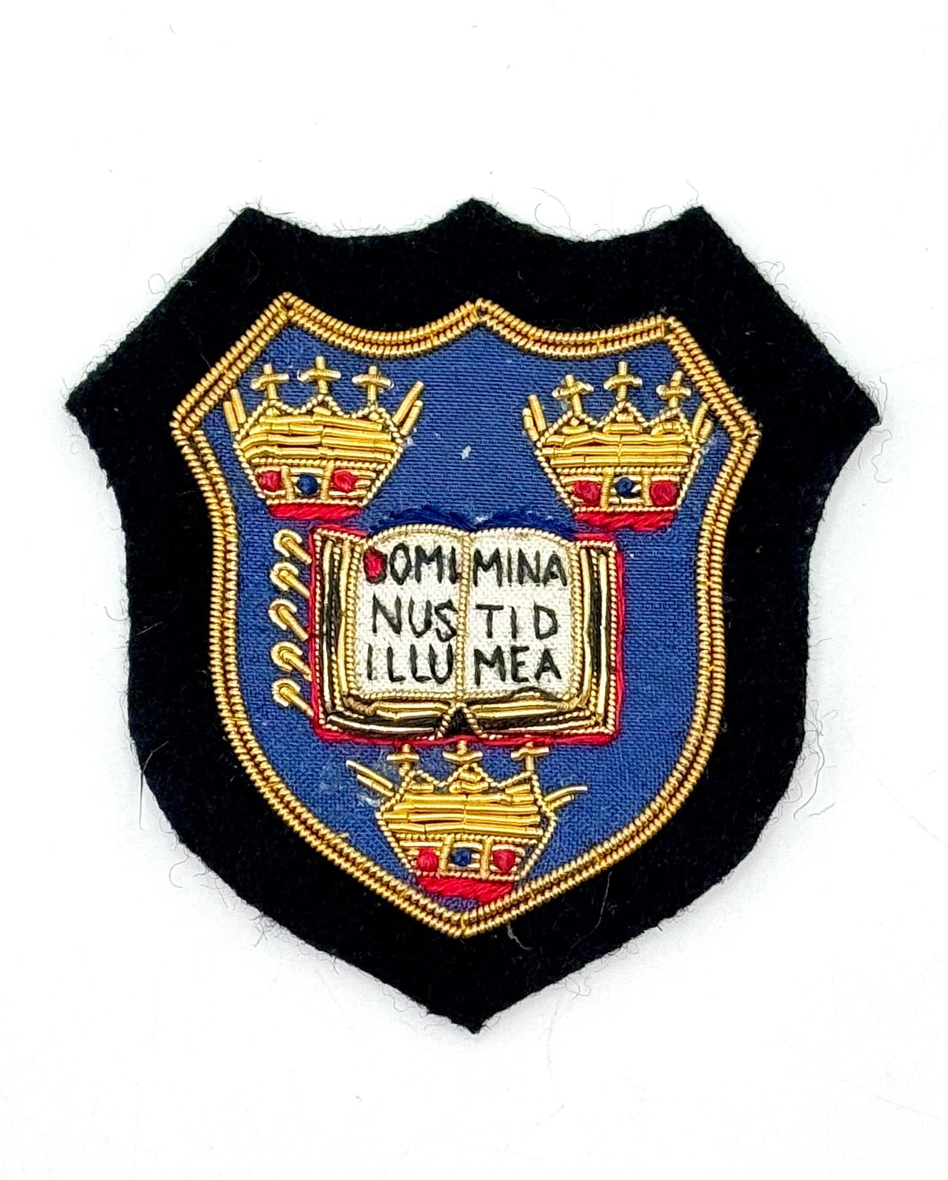 A Oxford University Coat of Arms bullion patch featuring a blue shield with a gold border, and intricate gold detailing including a crown and the text 'Omnis Minus Nus Tid I卢 Mea'. The patch is designed in a shield shape.