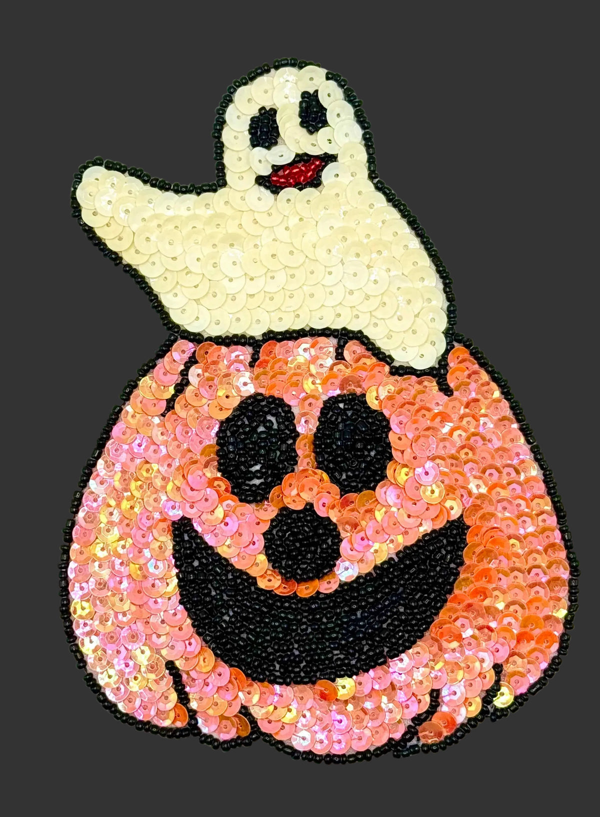 Sequined ghost in a pumpkin patch on a dark background