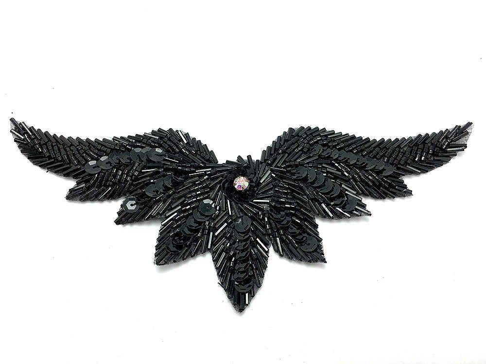 Black feather-like decorative item with sequins on a white background