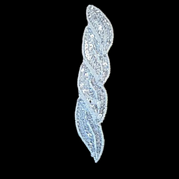 Decorative feather-shaped embellishment with sequins on a black background