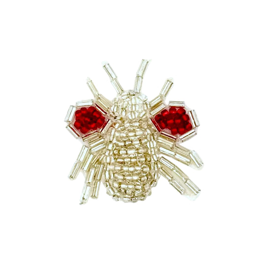 Beaded insect patch with red and silver glass beads on a white background