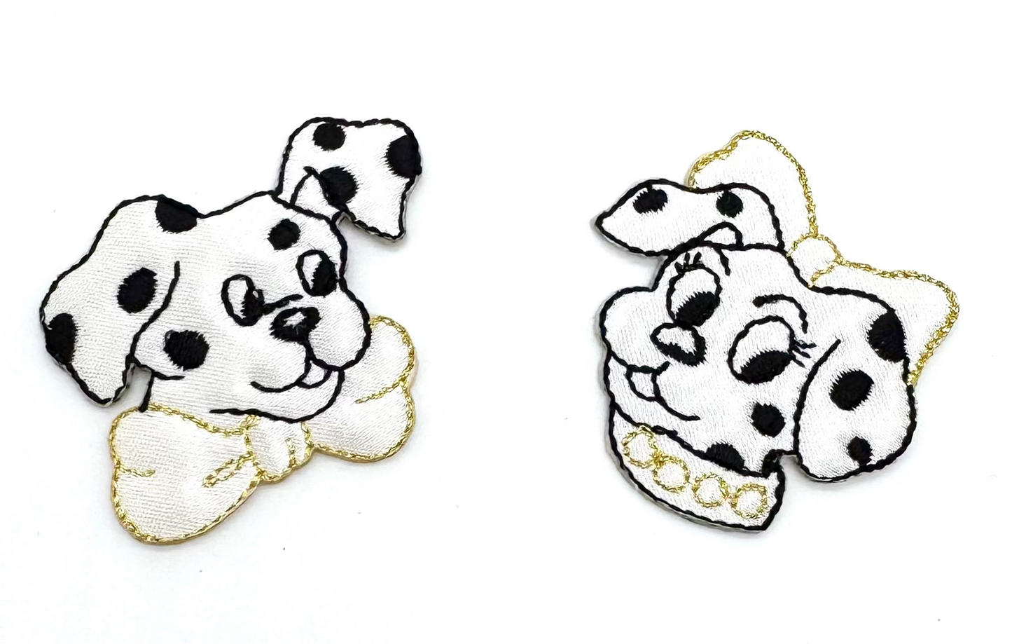 Two embroidered patches of Dalmatian dogs with black spots on a white background.