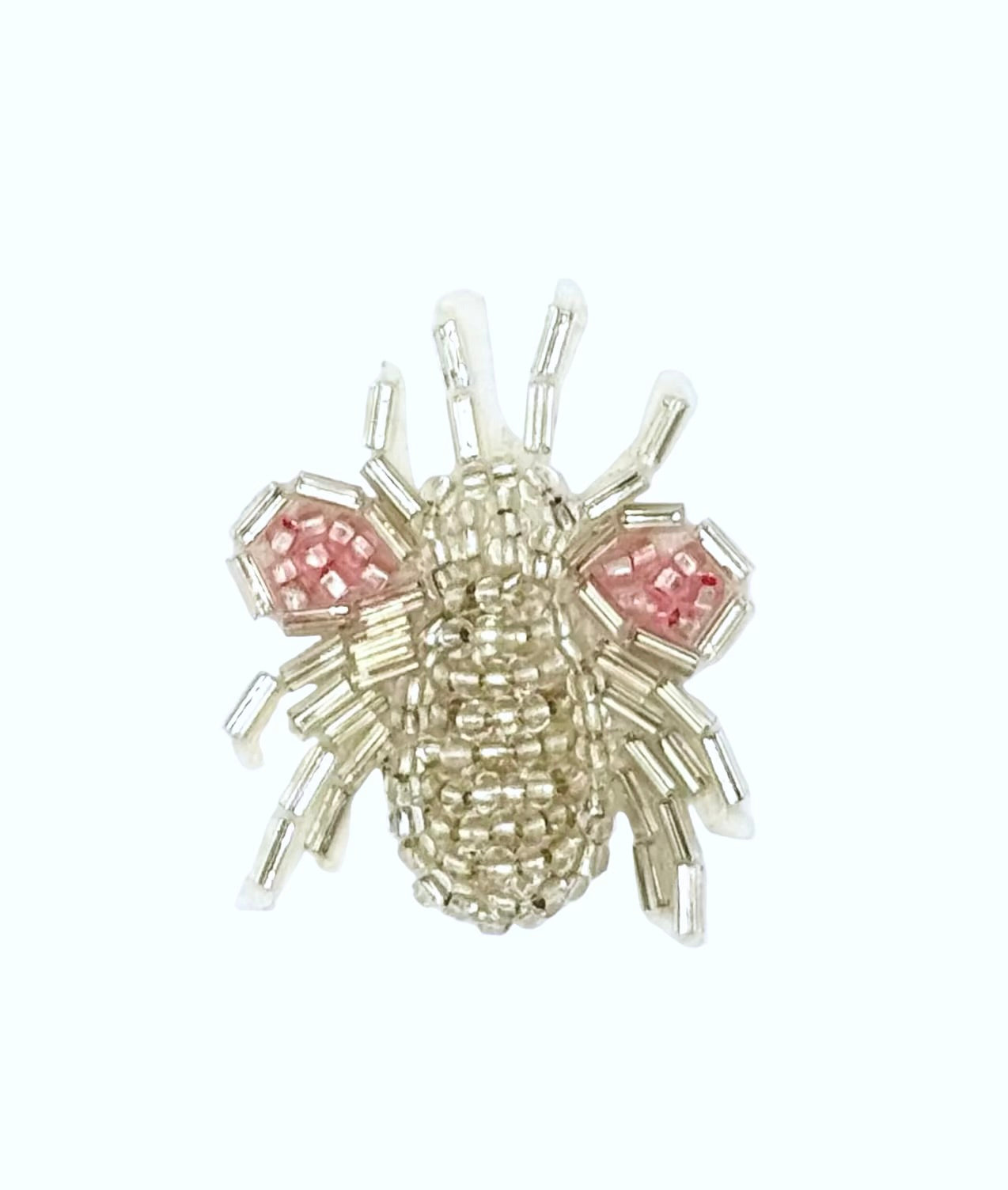 Beaded fly patch with silver and pink glass beads on a white background