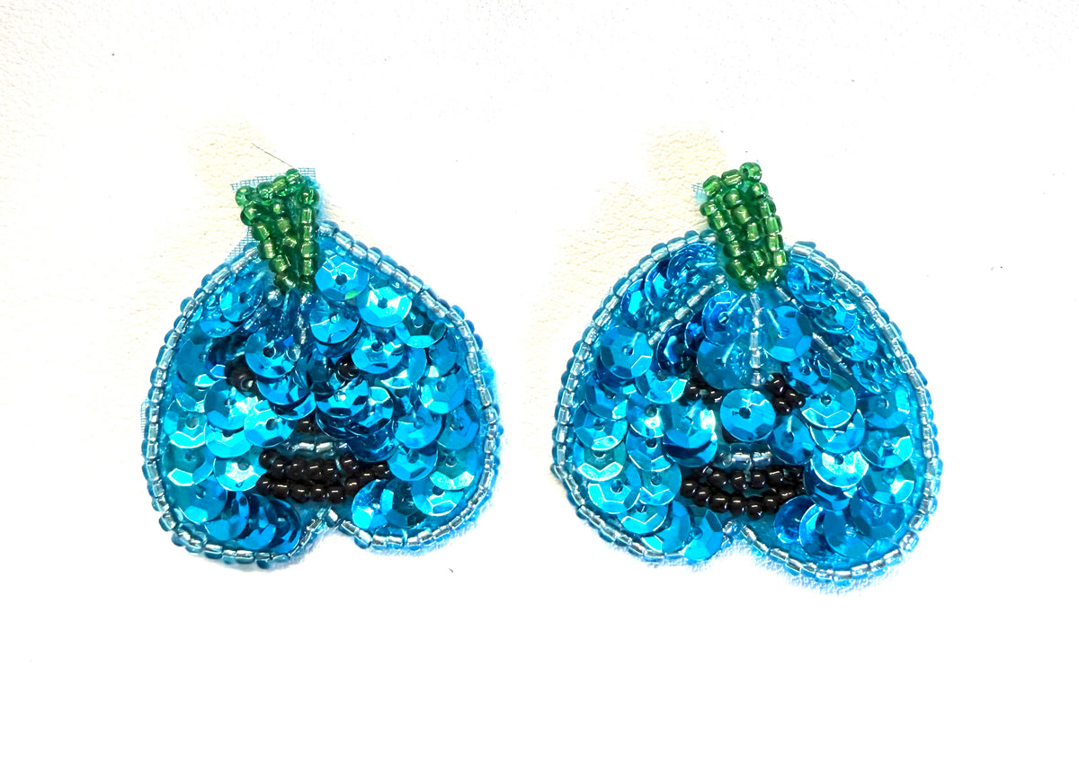 A pair of turquoise sequined pumpkin-shaped embellishments with green beaded stems and black bead details, shown on a plain white background.