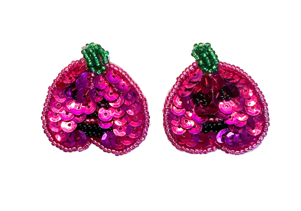 A pair of sequined pumpkin  embellishments or patches with bright pink and magenta sequins, green beaded stems, and a beaded border, shown on a plain white background.