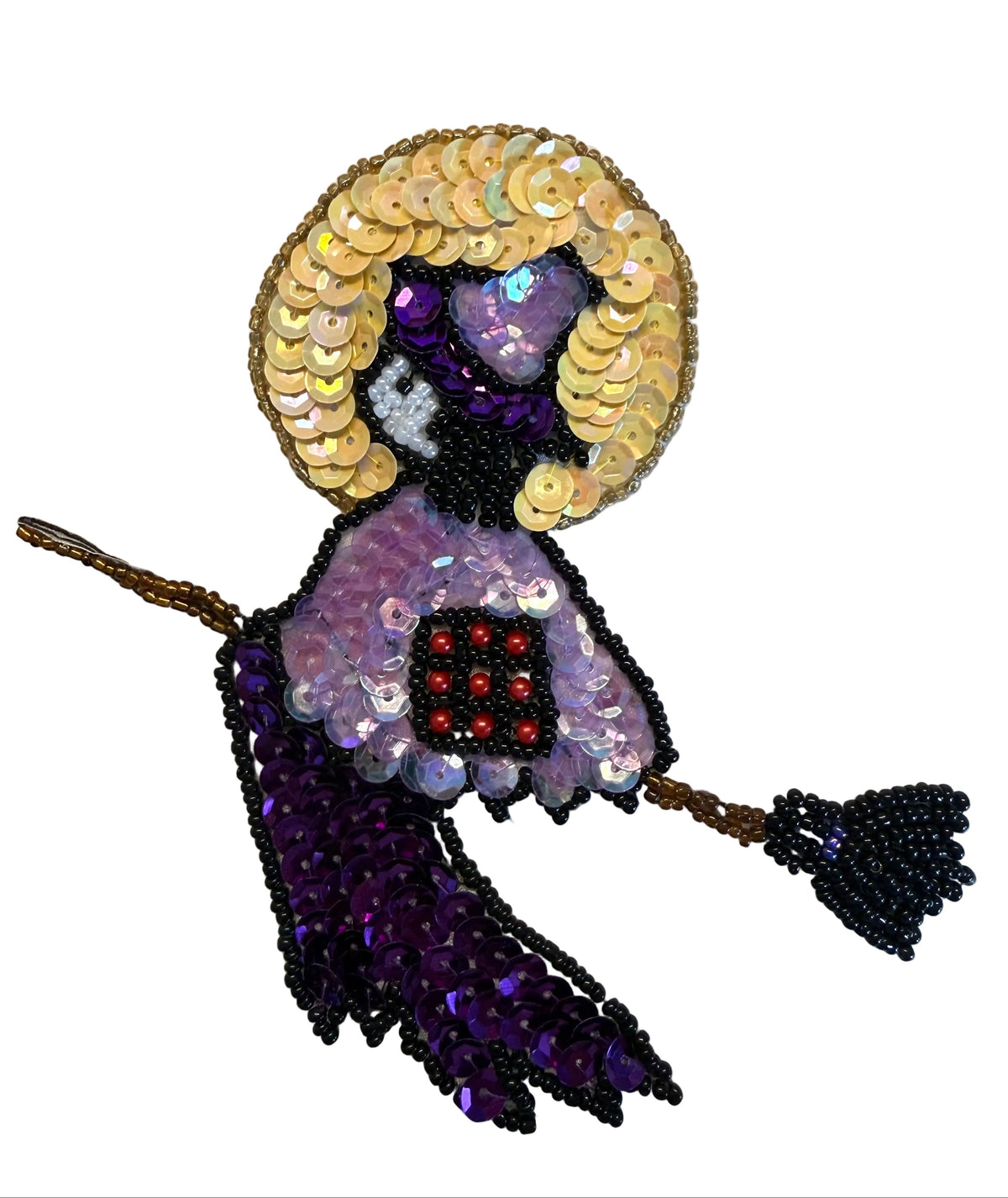 A Halloween witch patch made of sequins and beads, featuring a purple sequined body, a black sequined hat, a blonde sequin wig, and a black beaded broom, shown on a plain white background.