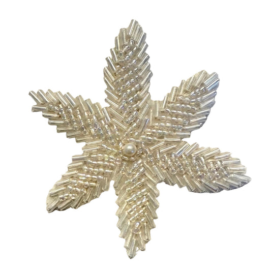 Add a delicate floral accent to your next project with this iridescent beaded flower appliqué. Shimmering beads surround a pearl center, creating a decorative focal point for your design.