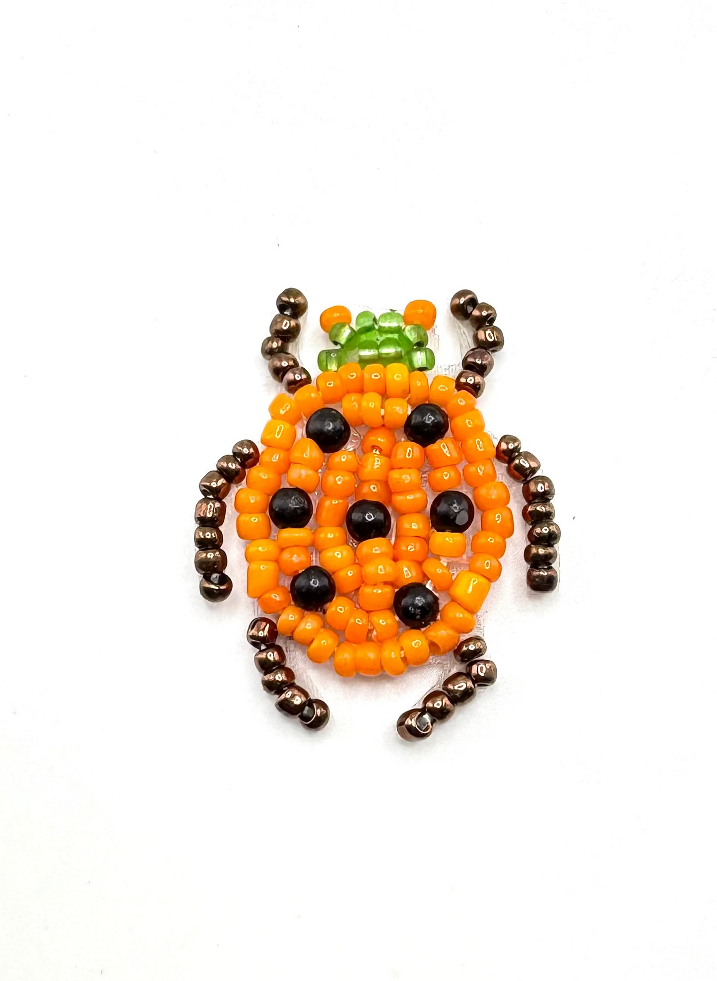 Beaded ladybug patch on a white background