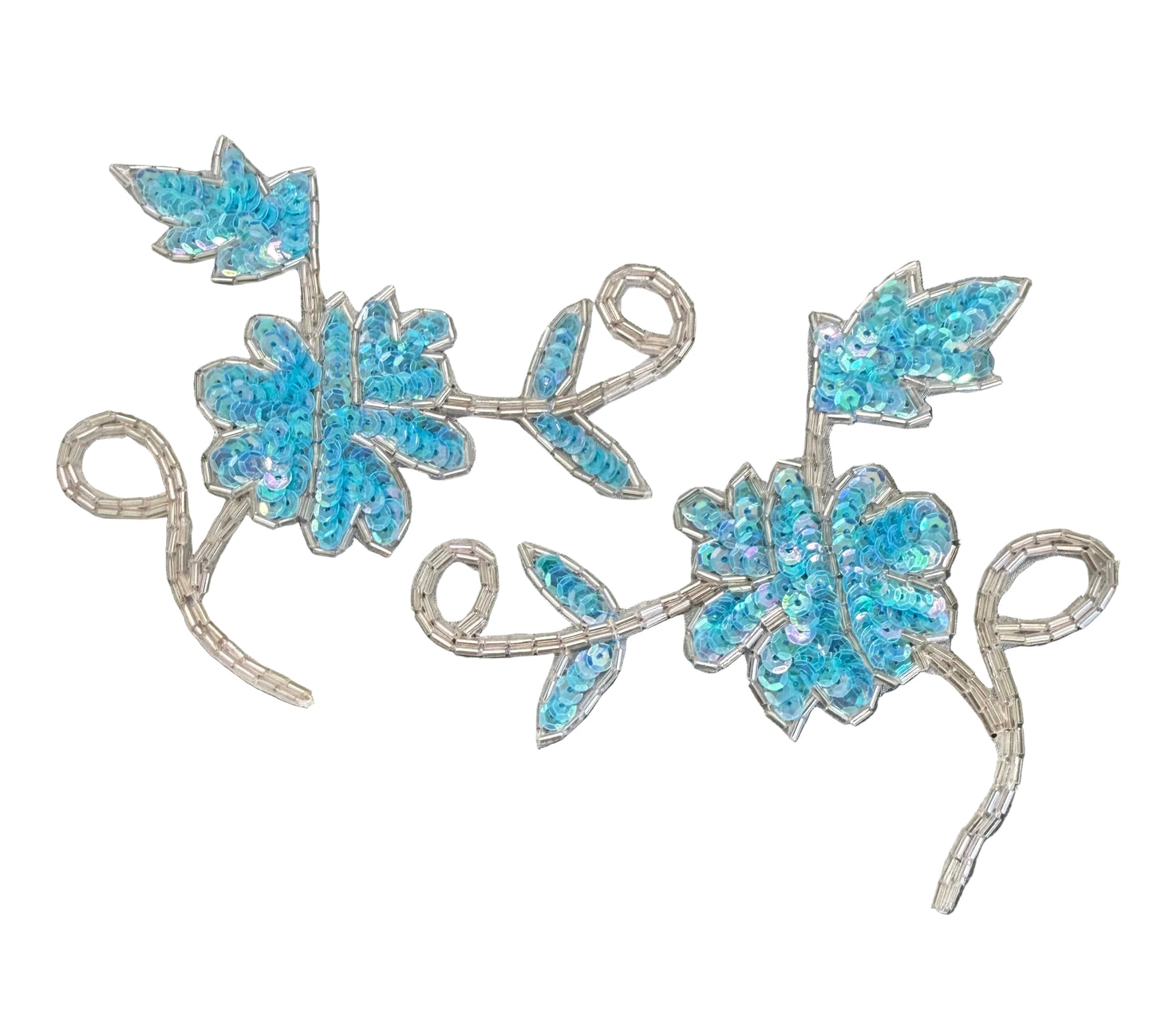 Two matching embroidered floral vine appliqués with bright blue sequins and silver sequined stems, displayed on a dark textured background.