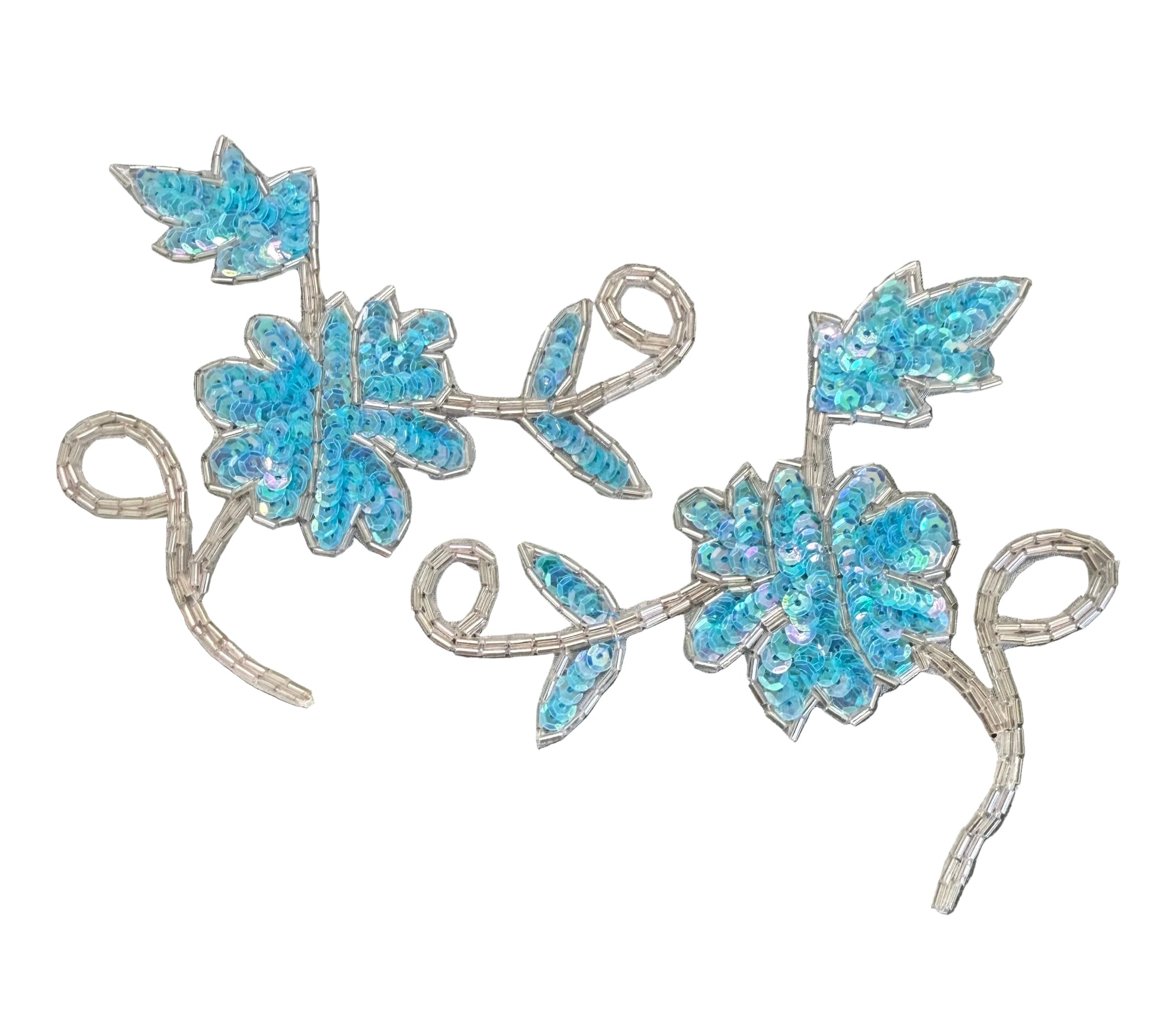 Two matching embroidered floral vine appliqués with bright blue sequins and silver sequined stems, displayed on a dark textured background.