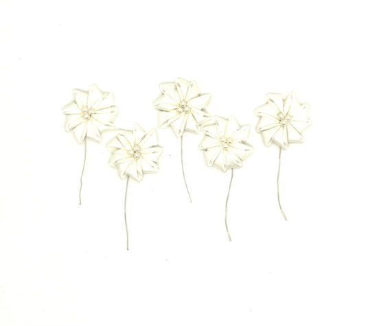 Five small white fabric flowers with thin wire stems, arranged on a plain white background.