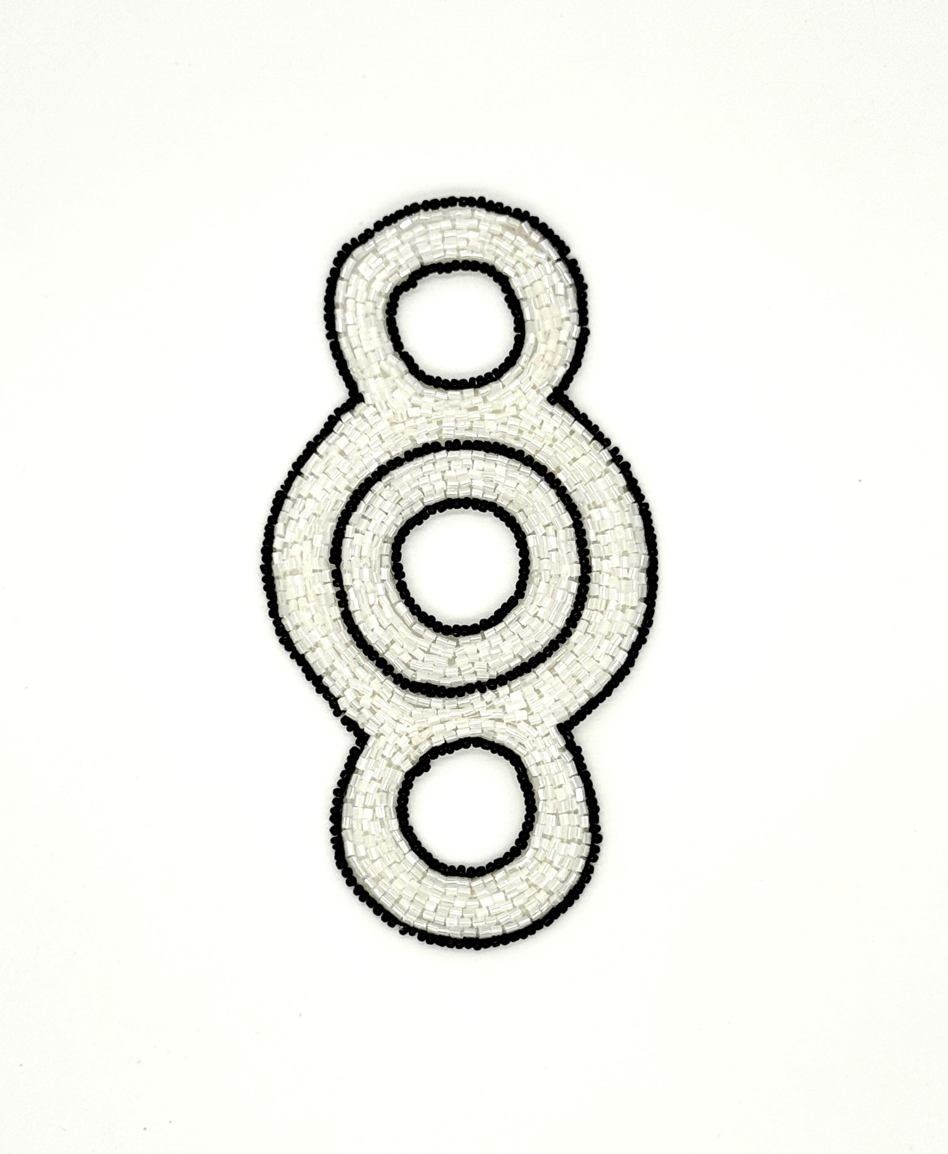 Decorative beaded accent with concentric circles on a white background