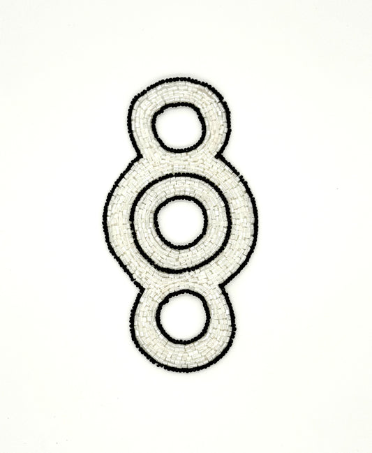 Decorative beaded accent with concentric circles on a white background