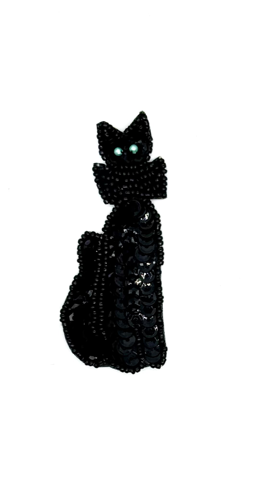 Black cat-shaped object with sequins on a white background