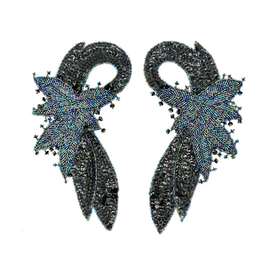 Pair of black beaded appliqués with beaded feather-like design on a white background