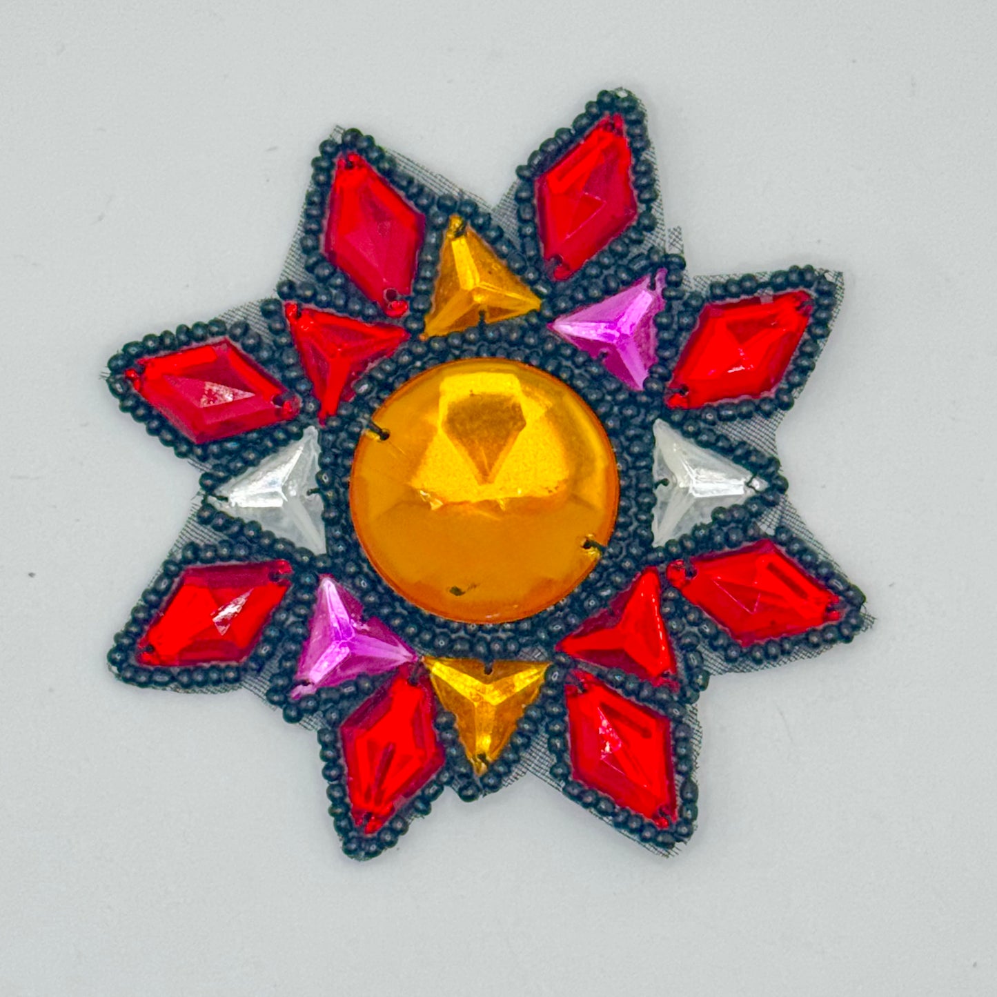 Motivo de diseñador de cuentas con pedrería roja, dorada, transparente, morada y negra y cuentas negras de 3.5" x 3.5"