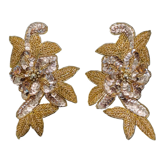 A pair of ornate floral appliqué patches with gold-tone sequined leaves and iridescent pink and silver sequined petals, displayed on a white background.