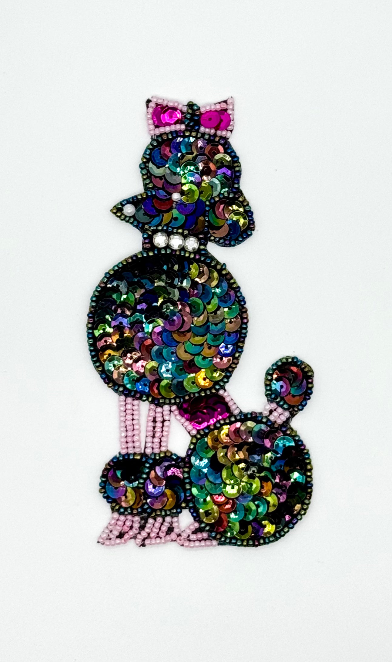Multicolored sequin and bead embellished poodle on a white background
