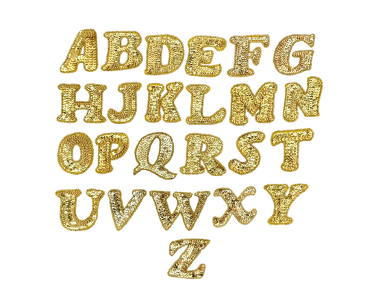 Gold sequin and bead alphabet letters on a white background