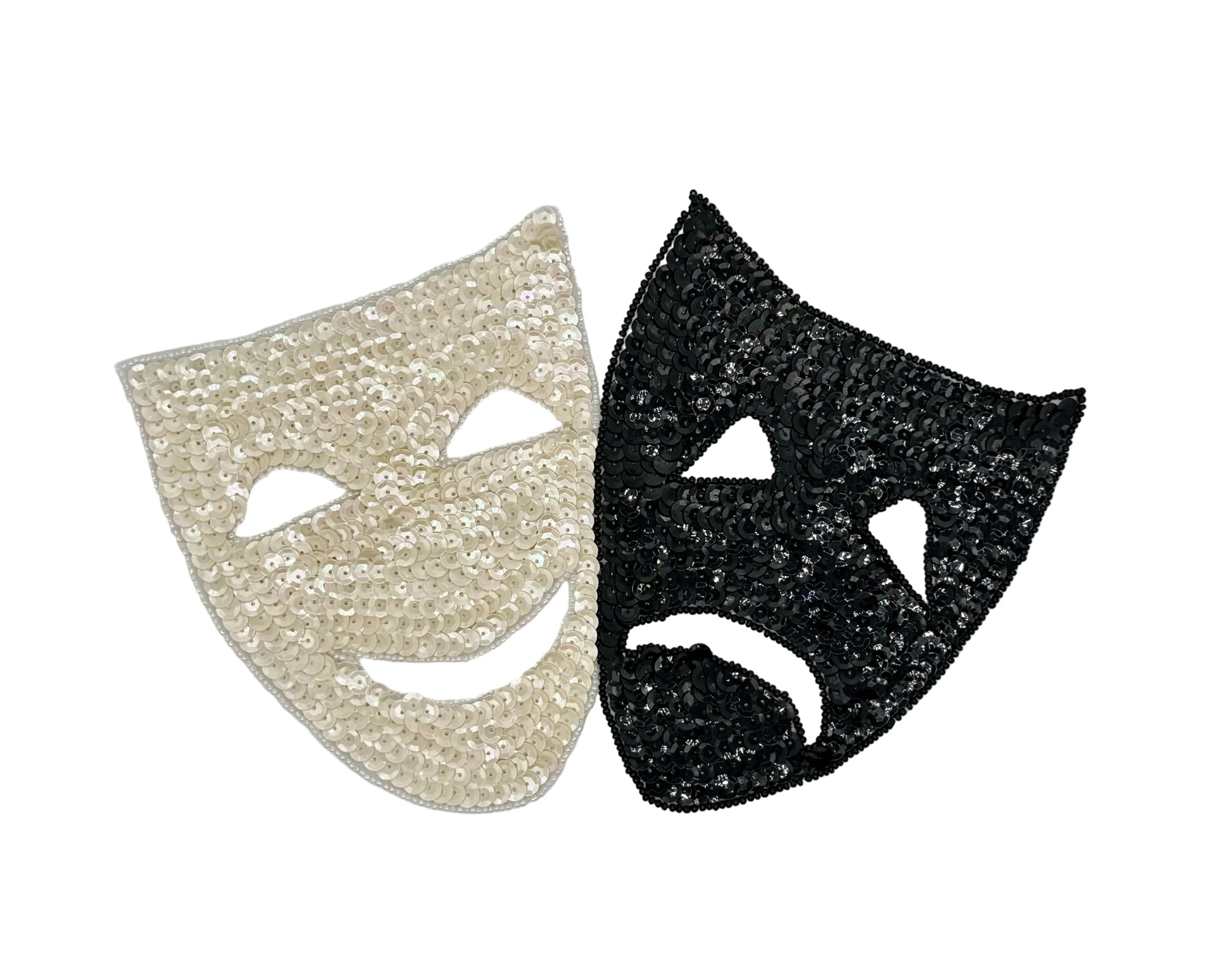 Two sequin theater masks, one white and one black, on a white background