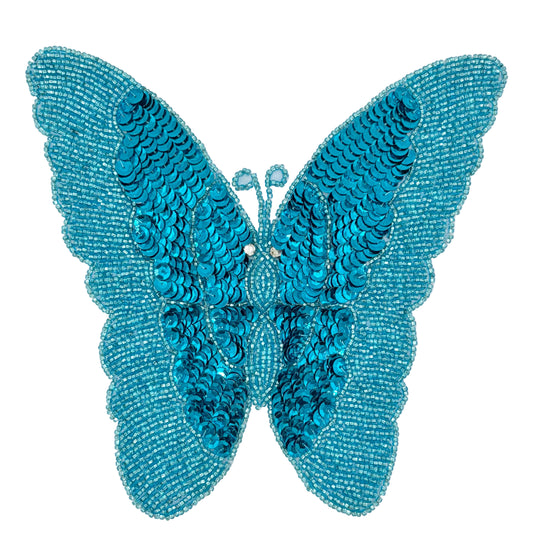 Turquoise butterfly-shaped decorative item with sequins on a white background