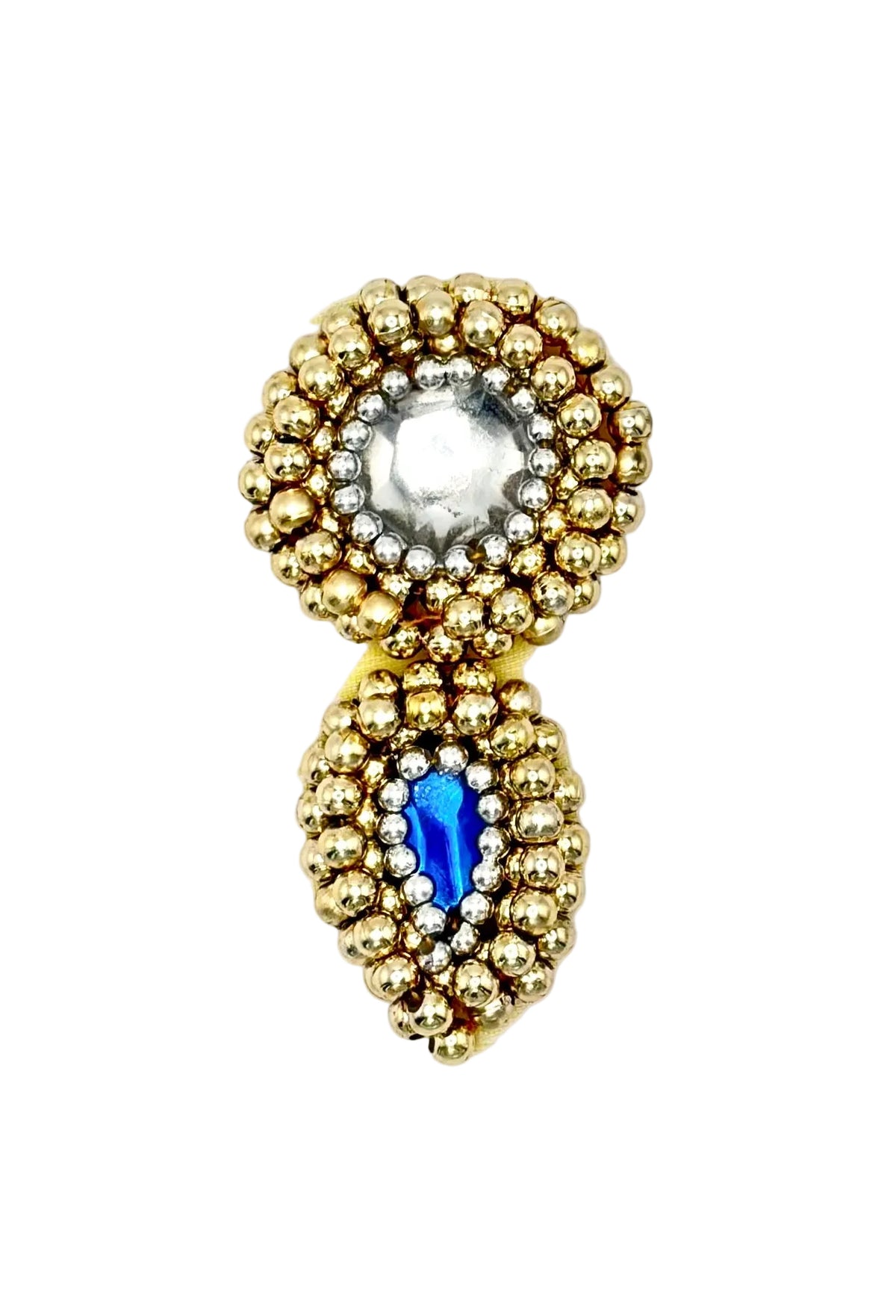 A vintage-style gold-toned appliqué  featuring a circular top section with a clear faceted center stone surrounded by small silver and gold beads, and a teardrop-shaped lower section with a blue teardrop shaped center stone surrounded by small silver and gold beads,  on a white background.