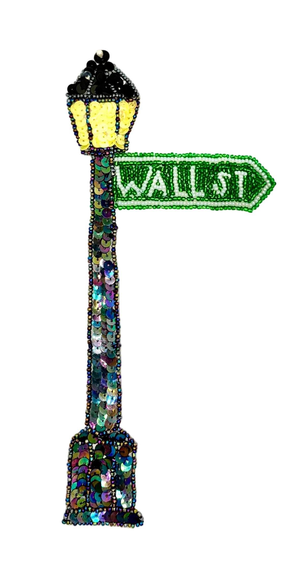 A decorative street sign shaped like a lamp post, covered in iridescent sequins and beads. The sign reads "WALL ST" in white on a green arrow-shaped plaque, with a black and yellow beaded lamp post above on a plain white background.