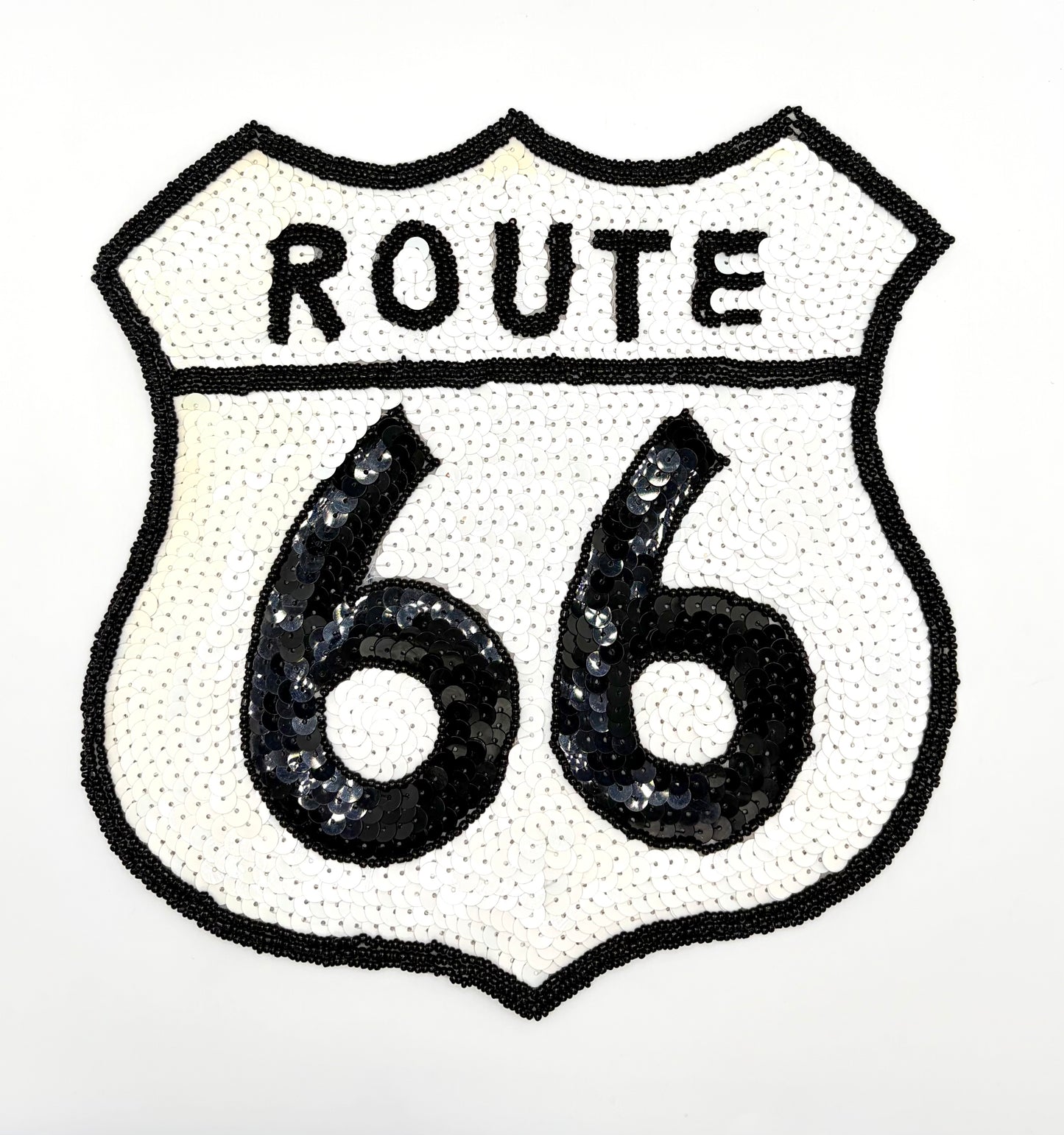 A shield-shaped Route 66 patch featuring black sequins on a white background, with 'ROUTE' arched above large '66' numerals.