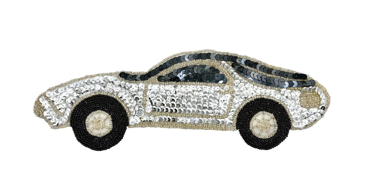 A sequined car-shaped applique patch featuring a silver body with black wheels and a black roof, displayed on a plain white background.