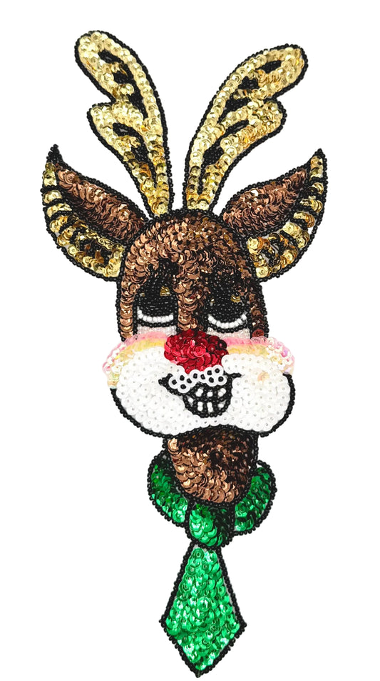 A festive Christmas-themed sequin patch featuring a reindeer head with gold antlers, brown fur, a red nose, a white snout, and a green bow tie, shown on a plain white background.