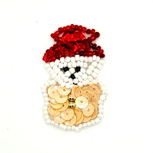 A handmade snowman embellishment made from red sequins for the hat, white beads for the face and body outline, beige sequins for the torso, and small black beads for the eyes, shown on a plain white background.